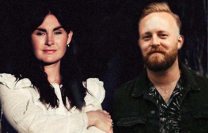 Två personer framför en svart bakgrund