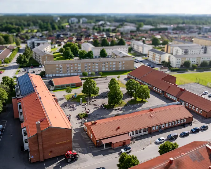 En flygbild av en stor skolbyggnad omgiven av bostadshus.
