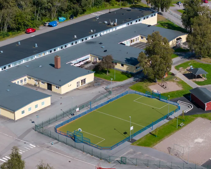 En flygbild av en skolbyggnad och en fotbollsplan.