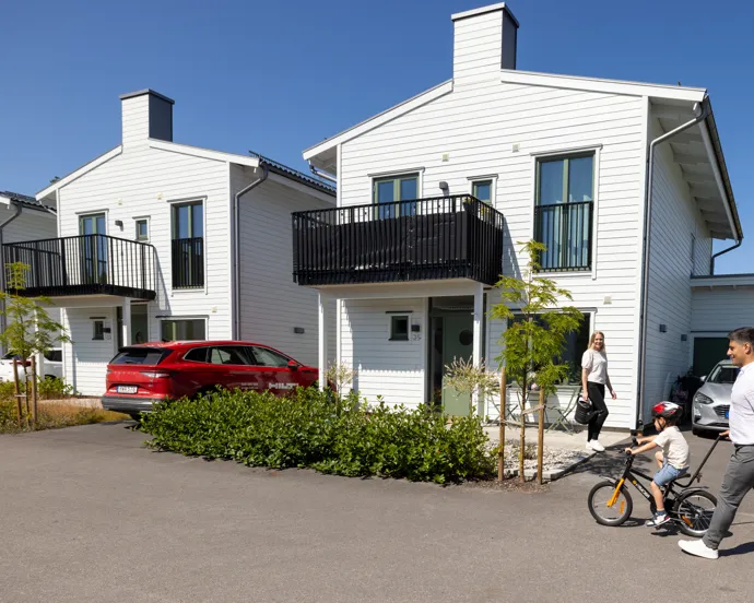 En man och en kvinna går förbi ett vitt hus.