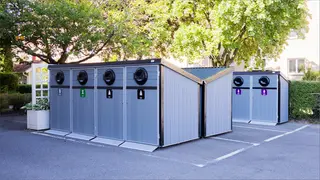 Bilden visar ett fristående sorteringsutrymme utomhus för flerbostadshus. 