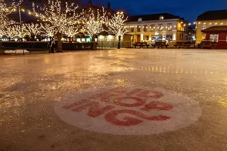 Bilden visar isbanan på torget. På isen syns platsvarumärket Lidköping. 